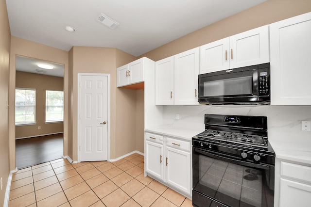 kitchen featuring light tile patterned floors, white cabinetry, black appliances, and light countertops