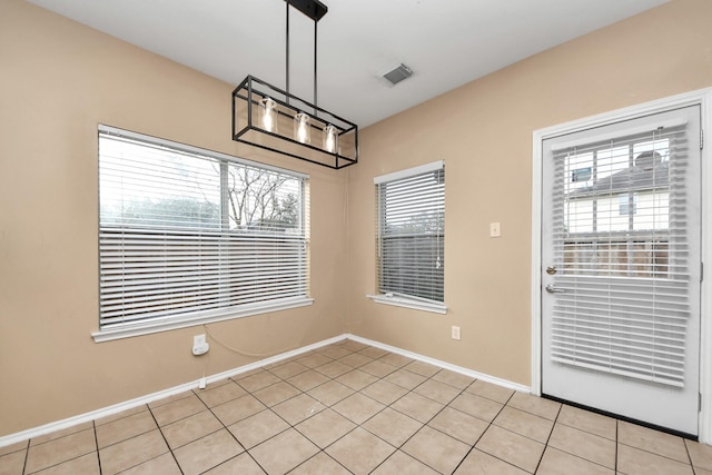 unfurnished dining area with light tile patterned floors, visible vents, and baseboards