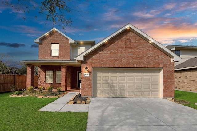 traditional-style house featuring brick siding, fence, concrete driveway, a front yard, and a garage