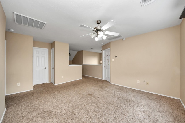 carpeted spare room with baseboards, visible vents, and ceiling fan