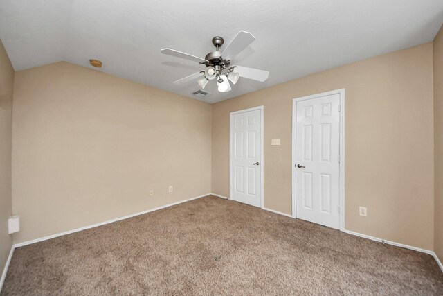 unfurnished bedroom with visible vents, a ceiling fan, carpet flooring, baseboards, and vaulted ceiling