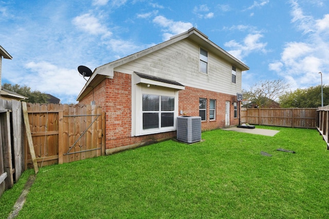 back of property with brick siding, central AC, a fenced backyard, and a lawn