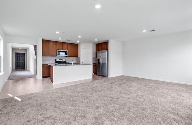 kitchen with light tile patterned floors, recessed lighting, stainless steel appliances, light colored carpet, and open floor plan