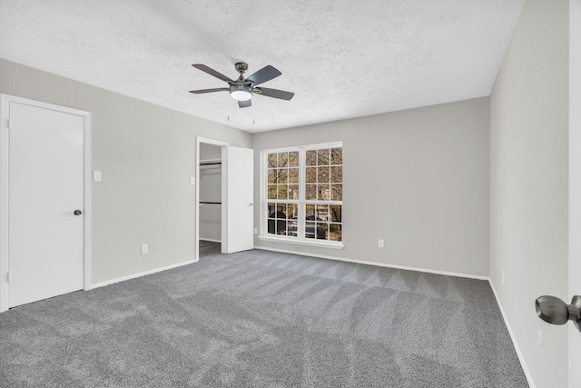 unfurnished bedroom featuring a ceiling fan, baseboards, a textured ceiling, and carpet flooring