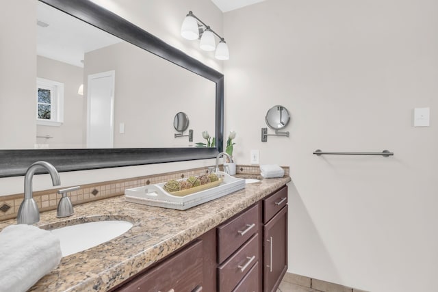 full bathroom with double vanity, tile patterned floors, and a sink