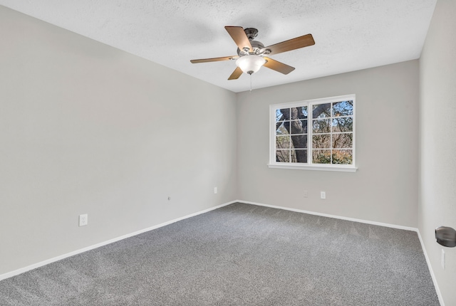 empty room with dark colored carpet, baseboards, a textured ceiling, and ceiling fan