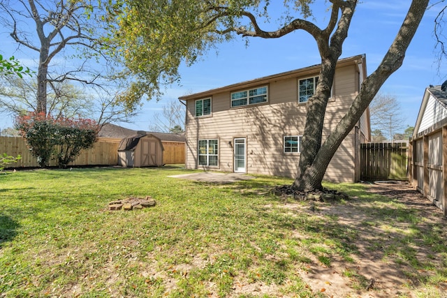 rear view of house with a shed, a patio area, a yard, a fenced backyard, and an outbuilding