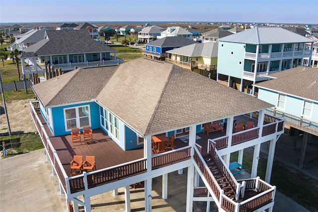 back of property with a residential view and roof with shingles