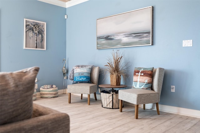 living area featuring baseboards, wood finished floors, and ornamental molding