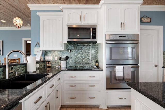 kitchen with white cabinets, appliances with stainless steel finishes, crown molding, and a sink