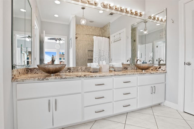 full bath with ceiling fan, ornamental molding, a tile shower, double vanity, and a sink