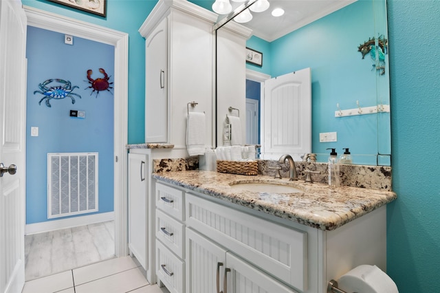 bathroom with visible vents, baseboards, ornamental molding, and vanity