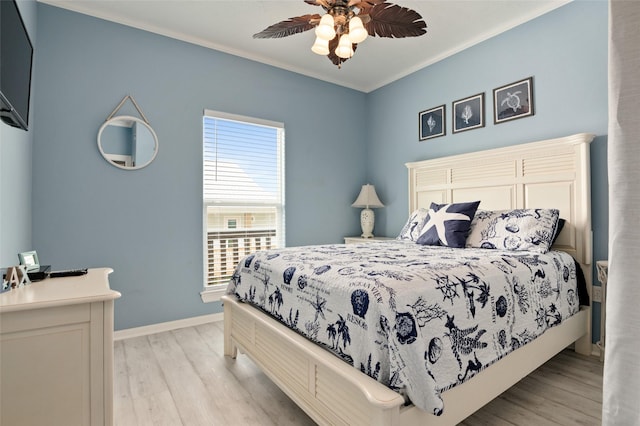 bedroom with baseboards, light wood-style floors, ceiling fan, and crown molding