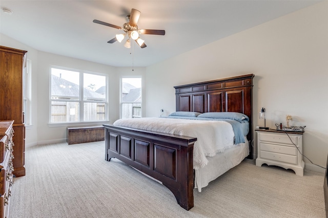 bedroom with a ceiling fan, light colored carpet, and baseboards