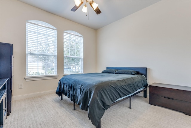 bedroom with multiple windows, a ceiling fan, baseboards, and carpet floors