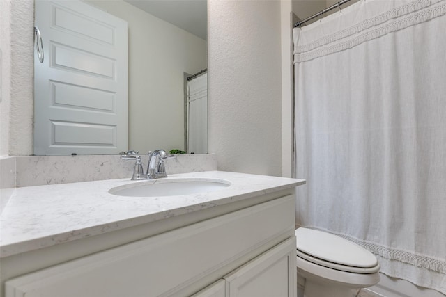 full bathroom with a shower with shower curtain, toilet, vanity, and a textured wall