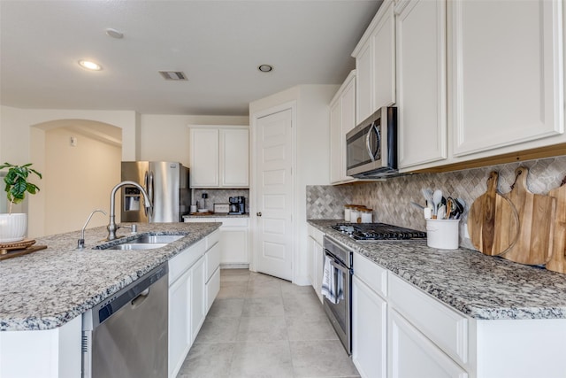 kitchen featuring visible vents, appliances with stainless steel finishes, light tile patterned flooring, white cabinetry, and a sink