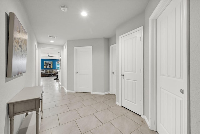 hallway with recessed lighting, light tile patterned floors, baseboards, and visible vents