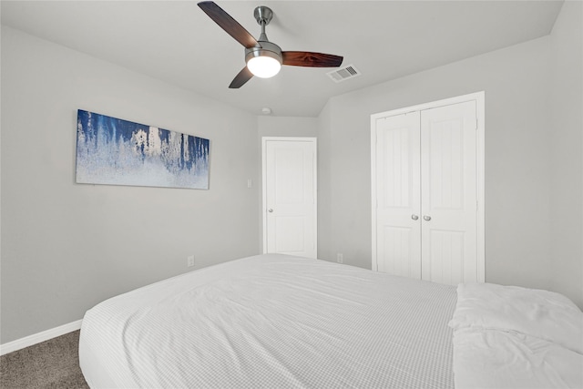 carpeted bedroom with baseboards, visible vents, a closet, and ceiling fan