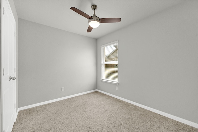 carpeted spare room with baseboards and a ceiling fan