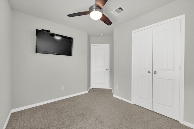 unfurnished bedroom featuring carpet, visible vents, a closet, and baseboards