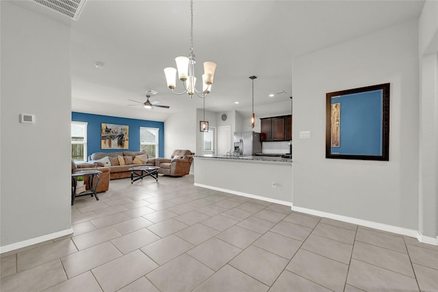 living area with light tile patterned floors, visible vents, and baseboards