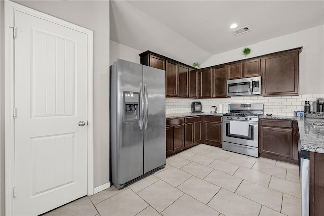 kitchen featuring visible vents, backsplash, light stone countertops, dark brown cabinetry, and stainless steel appliances