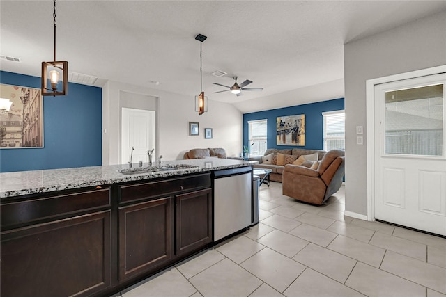 kitchen with a sink, light stone countertops, dark brown cabinetry, decorative light fixtures, and stainless steel dishwasher