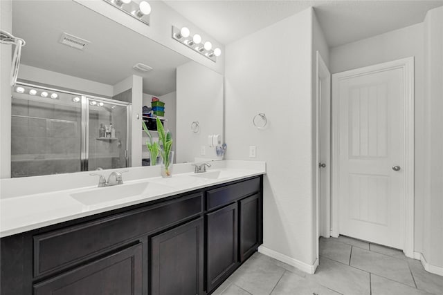 bathroom featuring visible vents, double vanity, a stall shower, a sink, and tile patterned floors