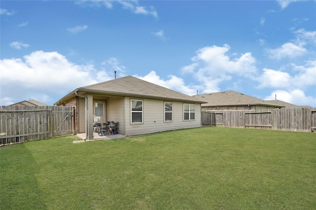 rear view of property with a patio, a lawn, and a fenced backyard