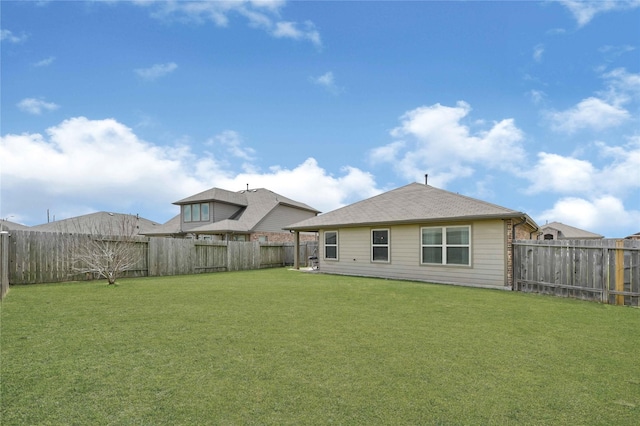 back of house with a lawn and a fenced backyard