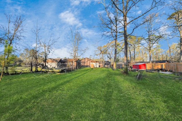 view of yard with an outdoor structure and fence