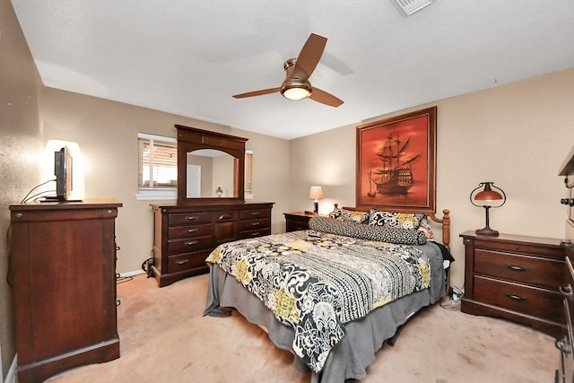 bedroom with light colored carpet, visible vents, and ceiling fan