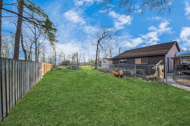 view of yard with a garage and a fenced backyard