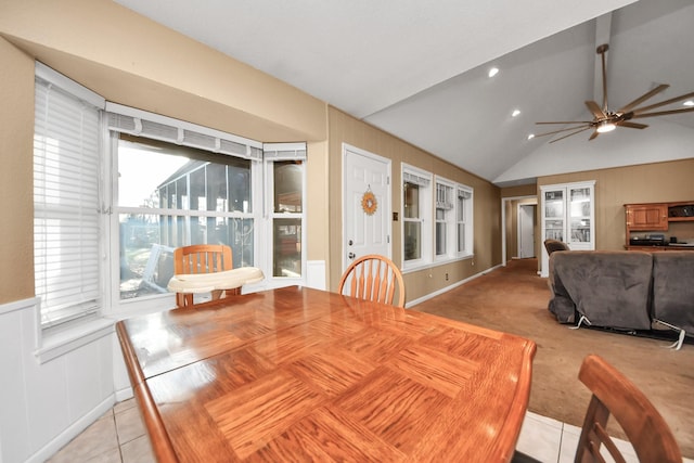 dining room with light tile patterned floors, light colored carpet, ceiling fan, and vaulted ceiling