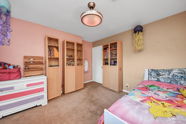 bedroom with baseboards and light colored carpet