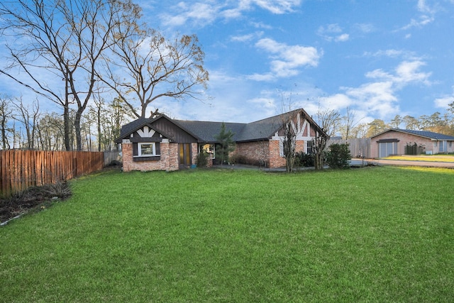 view of front of property with brick siding, a front lawn, and fence