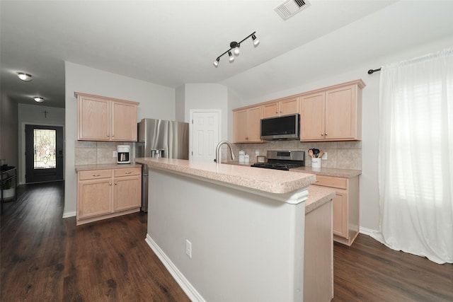 kitchen with visible vents, light brown cabinets, light countertops, vaulted ceiling, and stainless steel appliances