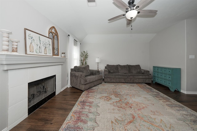 living room with visible vents, a fireplace, dark wood-type flooring, and vaulted ceiling