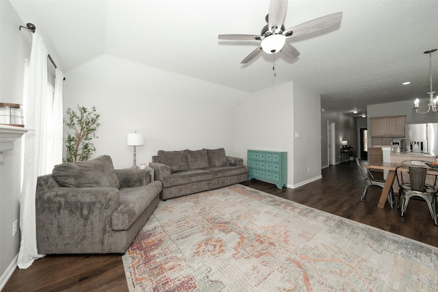 living room with ceiling fan with notable chandelier, dark wood-type flooring, baseboards, and vaulted ceiling