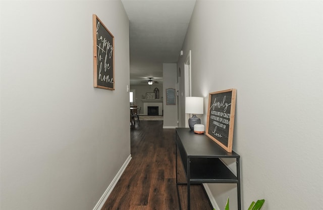 corridor with baseboards and wood finished floors