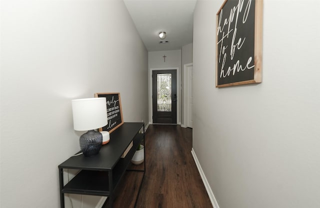 doorway to outside featuring visible vents, baseboards, and dark wood-style flooring