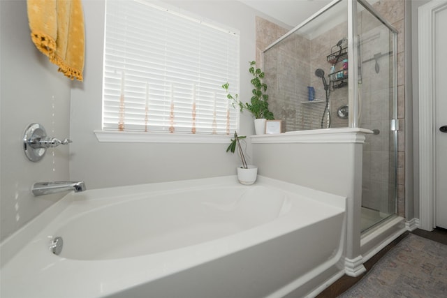 bathroom featuring a shower stall and a bath