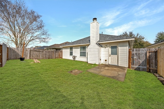 rear view of property featuring a lawn, a fenced backyard, and a chimney