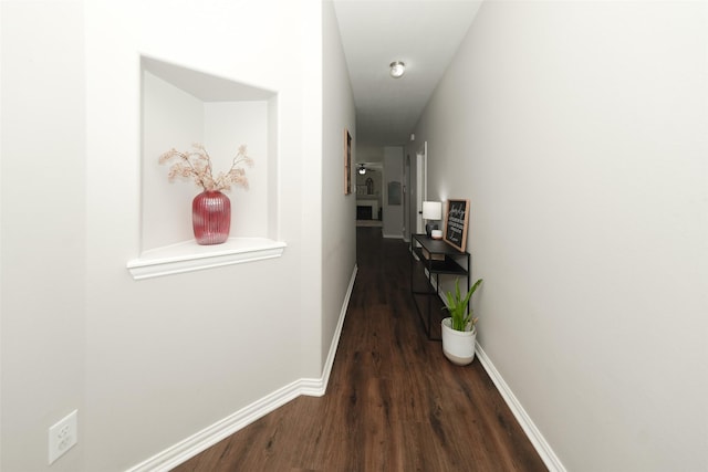 hallway with baseboards and wood finished floors