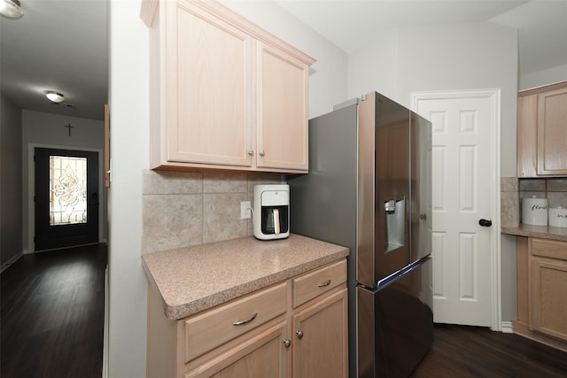 kitchen featuring light brown cabinetry, backsplash, stainless steel fridge, light countertops, and dark wood-style flooring