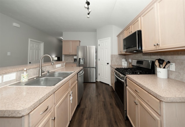 kitchen with backsplash, light brown cabinets, dark wood finished floors, appliances with stainless steel finishes, and a sink