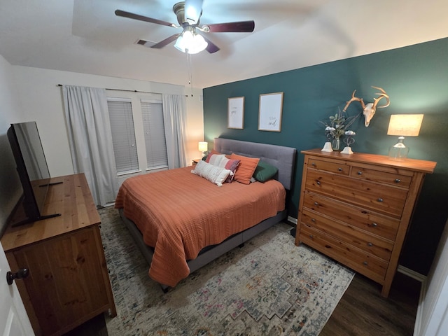 bedroom featuring a ceiling fan, wood finished floors, and visible vents