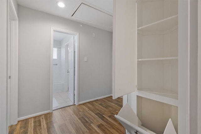 hallway with recessed lighting, attic access, baseboards, and wood finished floors