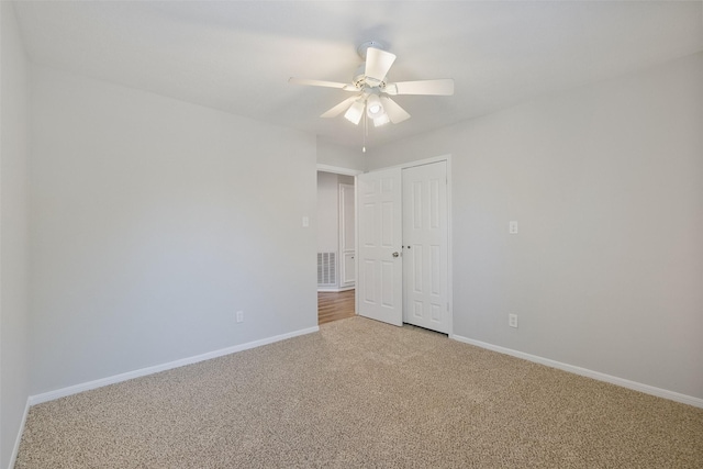 unfurnished bedroom featuring a closet, carpet flooring, visible vents, and baseboards